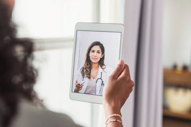 A female doctor offers an unrecognizable female patient advice during a telemedicine appointment.