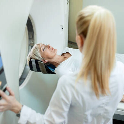 High angle view of mature woman and radiologist during MRI scan examination at clinic.